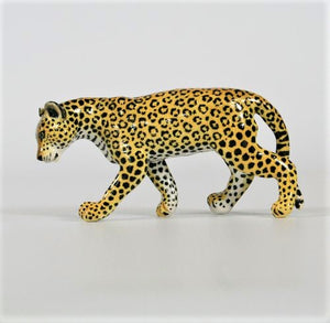 Small walking leopard with head down