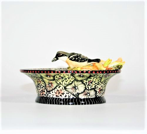 Small decorative bowl with white-throated robin & orange flower.