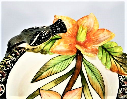 Small decorative bowl with white-throated robin & orange flower.