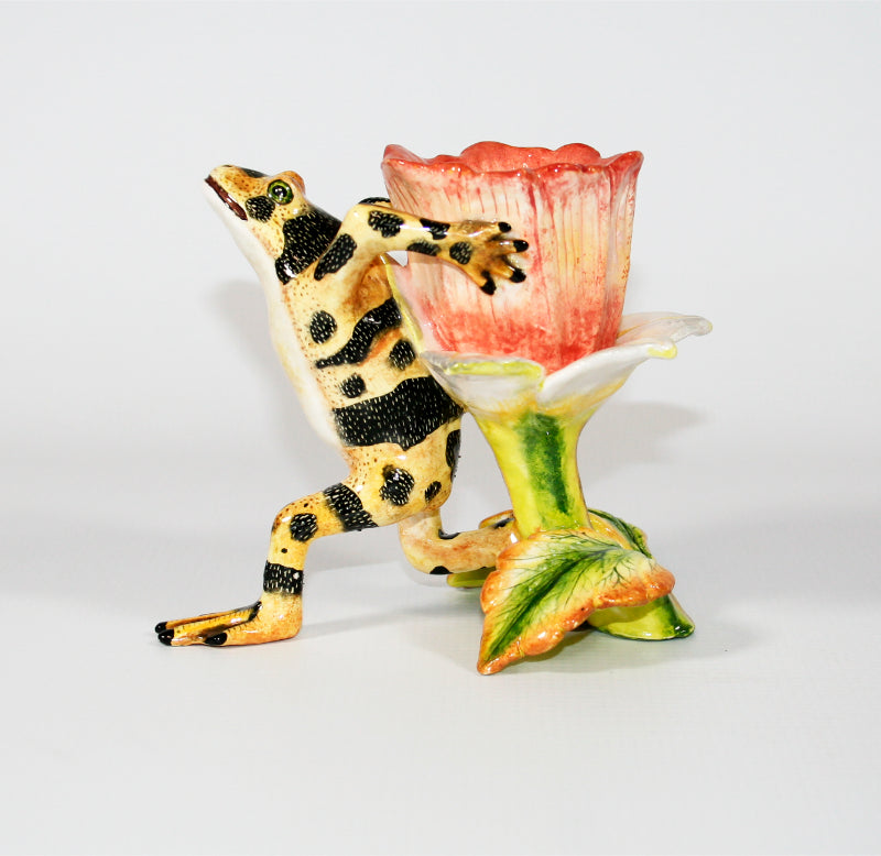 Yellow frog with black speckled stripes and pink flower toothpick holder