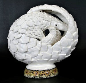 White curled pangolin on painted base