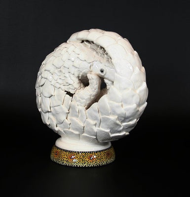 White curled pangolin on painted base