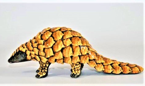 Small standing pangolin with curled tail