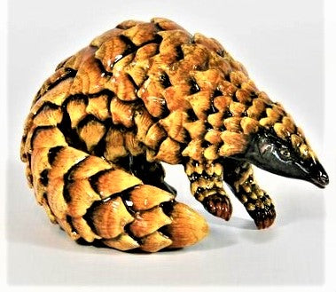 Small standing pangolin with curled tail