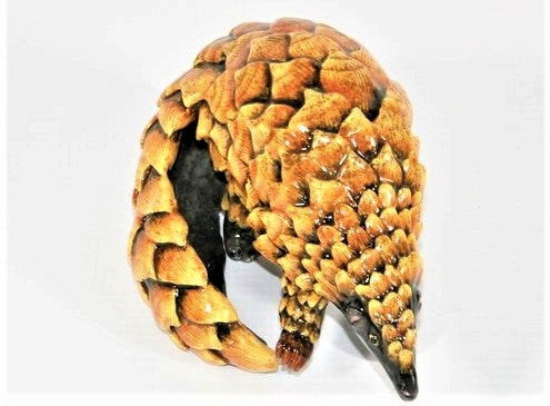 Small standing pangolin with curled tail